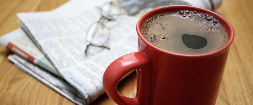 Kaffeetasse mit Zeitung und Brille