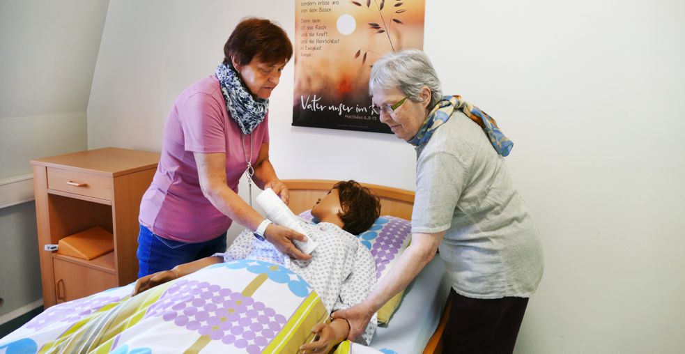 zwei Frauen bei einer Schulung am Pflegebett