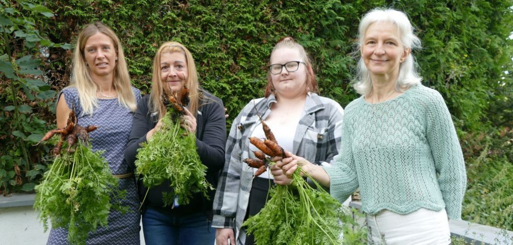 Gruppe mit selbst geernteten Möhren