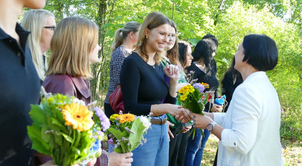 Neue Auszubildende bekommen Blumen und Gratulation beim Azubi-Empfang
