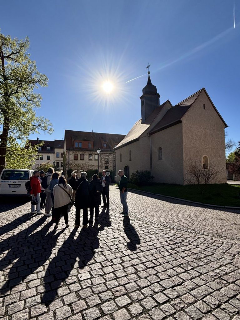 Gruppe von Menschen vor einer Kirche im Licht im Sonnenlicht