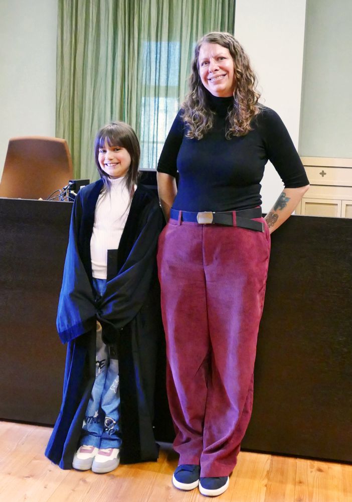 Kind mit Robe neben Richterin
