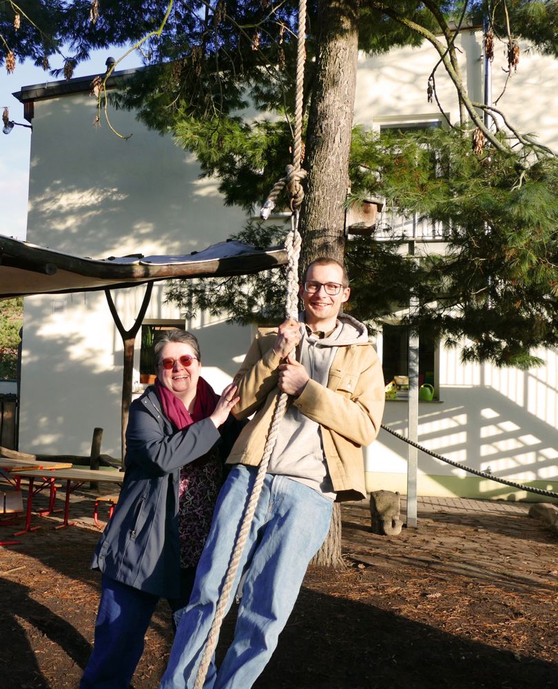 Erzieherin und junger Mann an der Schaukel