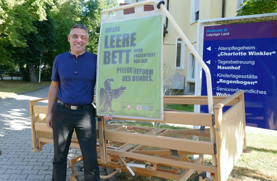 Heimleiter vor leerem Pflegebett bei Protestaktion gegen Entwurf Pflegereform