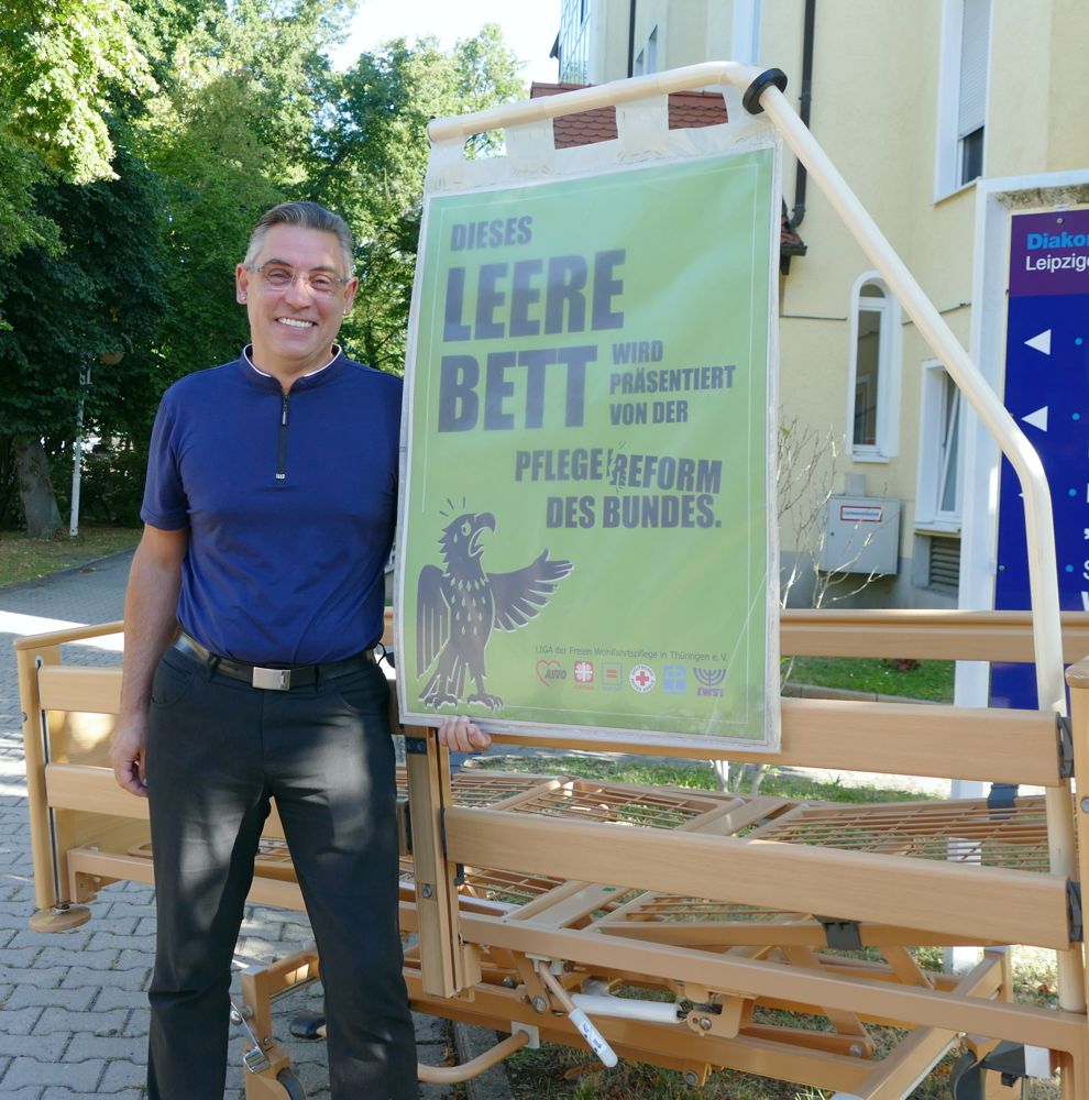 Heimleiter vor leerem Pflegebett bei Protestaktion gegen Entwurf Pflegereform