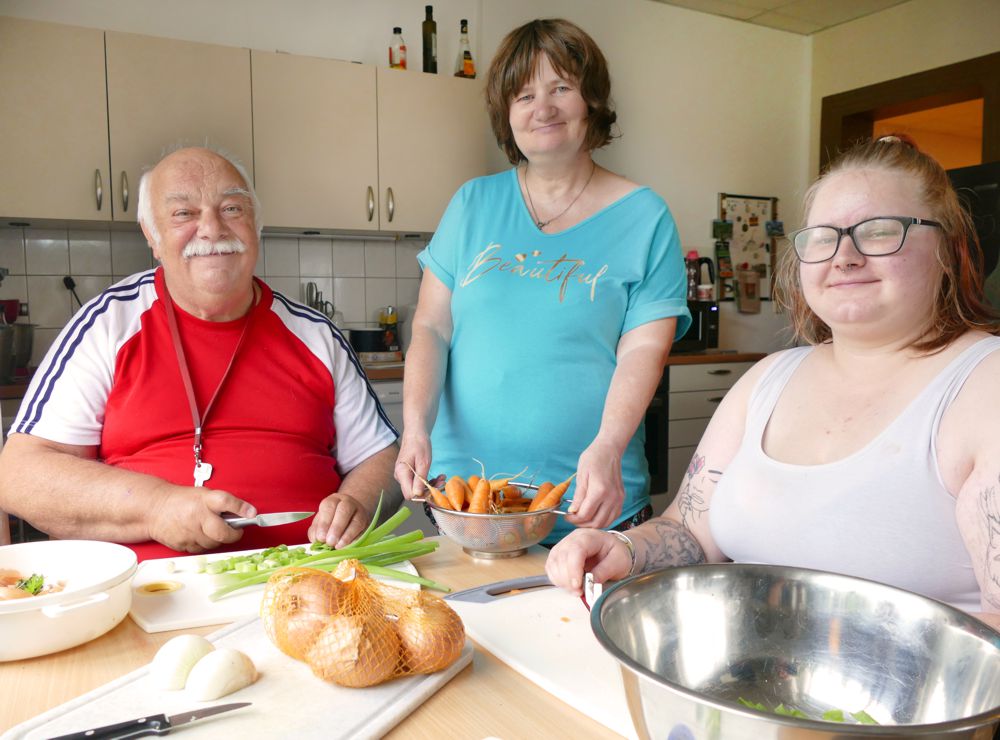 Gruppe beim Kochen von Möhreneintopf