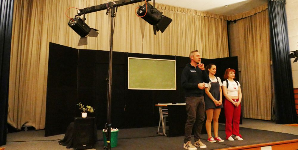 Schulsozialarbeiter mit 2 Schauspielerinnen auf der Bühne vor der Aufführung eines Stücks über Mobbing im Kino Groitzsch