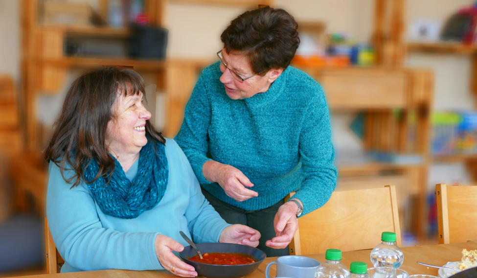 Frau serviert einer Besucherin Suppe beim Projekt "Tischlein deckt sich"
